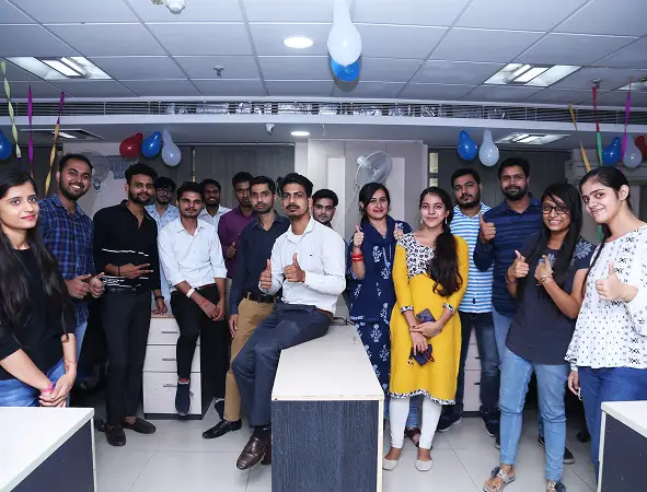 Maxtra Technologies employees posing together in a decorated office during a team engagement event